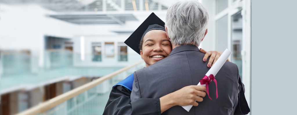 two people hugging, one has just graduated